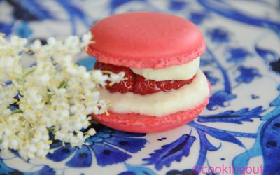 Un joli petit macaron tout rose parfumé à la fraise sur une ganache au sirop de fleurs de sureau.