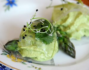 raviole de fane de navet et d'angélique servie avec asperge et germes de poireaux