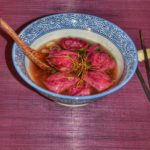 Ravioles roses parfumées à la betterave farcie aux légumes dans un bouillon d'épluchures de légumes