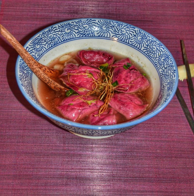 Ravioles roses parfumées à la betterave farcie aux légumes dans un bouillon d'épluchures de légumes