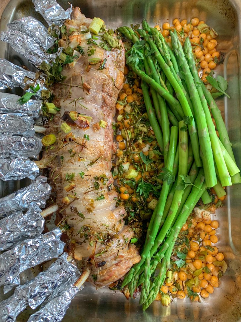 carré d'agneau cuit avec du zaatar, de l'aillet et servi avec asperges et pois chiches grillés